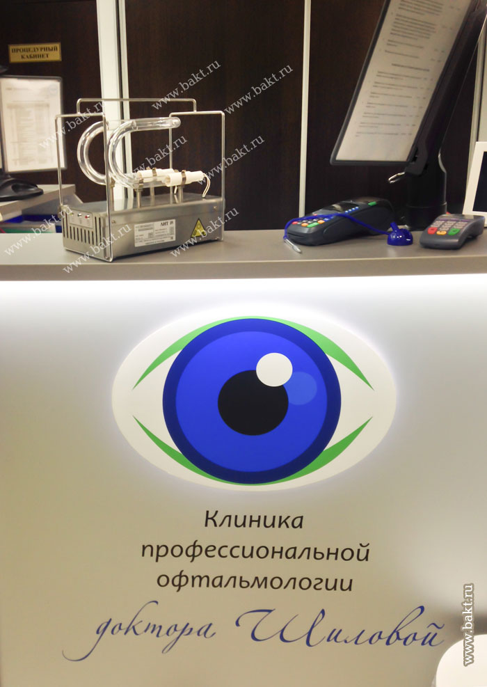 Фото облучателя «Светолит-50» на ресепшен стойке администратора, на фоне логотипа клиники профессиональной офтальмологии доктора Шиловой